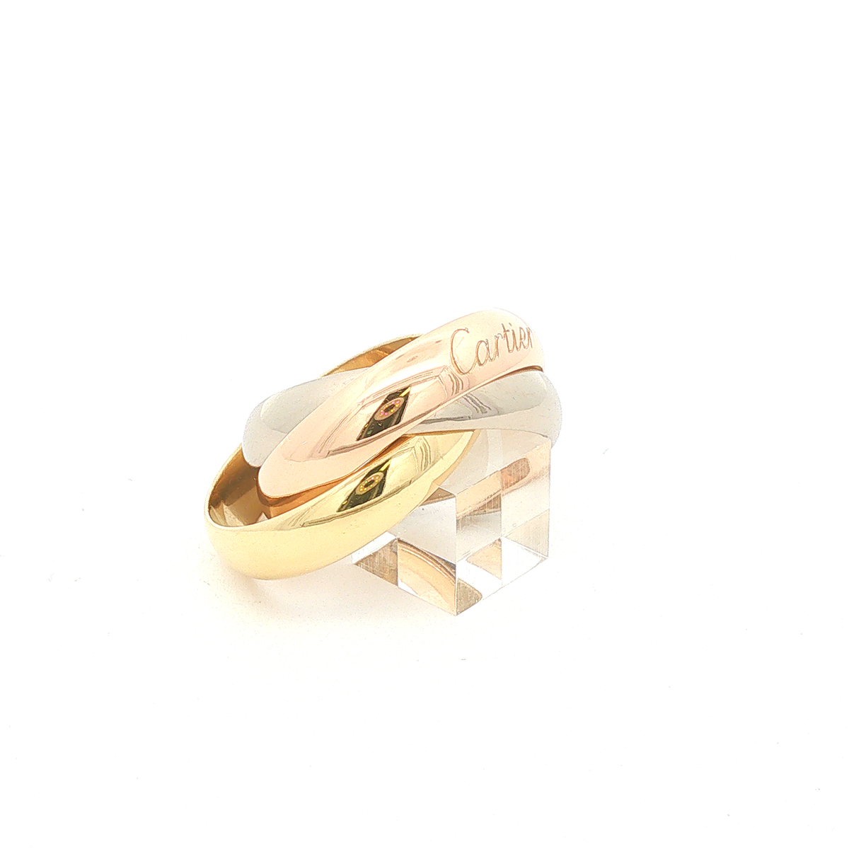 Cartier Trinity Ring aus 18 Karat Gelb-, Rosé- und Weißgold, Ringgröße 58, ohne Steinbesatz, in charakteristischer Tricolor-Gestaltung, Schrägansicht. 